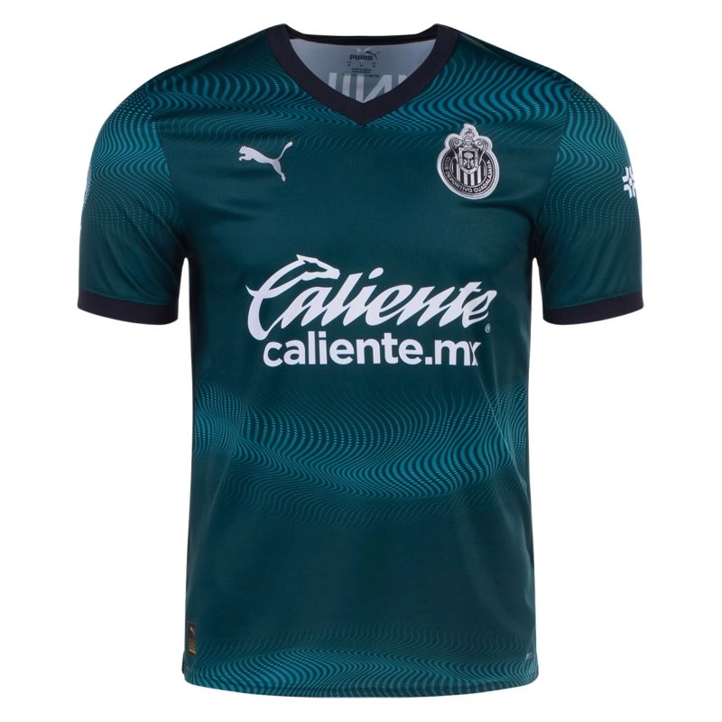 2023-2024 Chivas de Guadalajara third jersey in dark teal with subtle wave pattern, featuring Puma logo and 'caliente.mx' sponsor.
